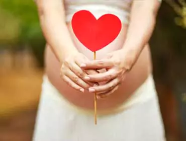 A girl holding a heart shape props